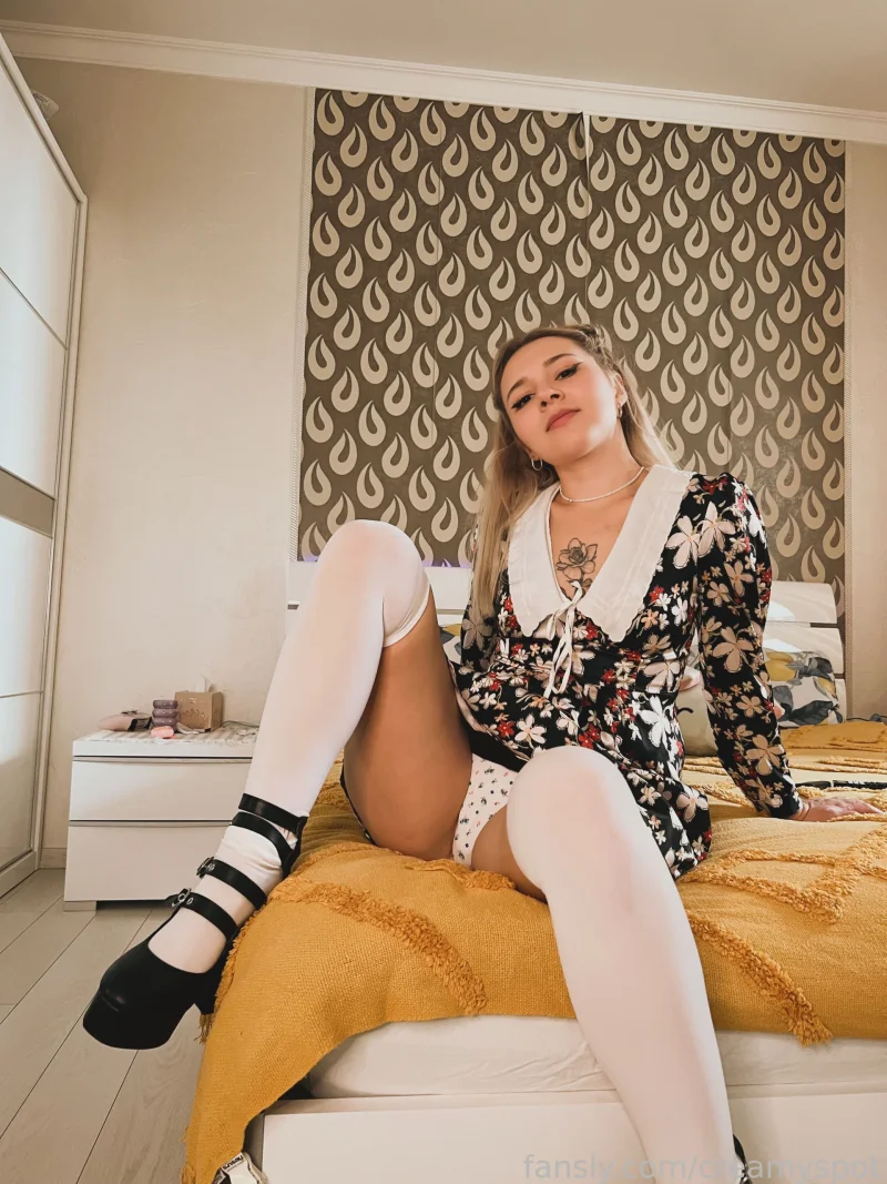 Naughty Creamy Spot in floral dress and white thigh highs spreads her legs on bed