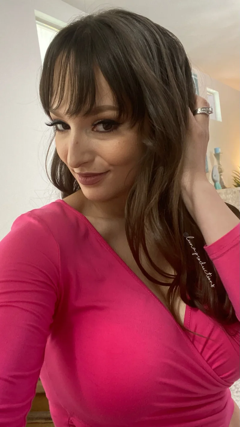 Sexy Lexi Luna in a tight pink top posing with her hand in her hair